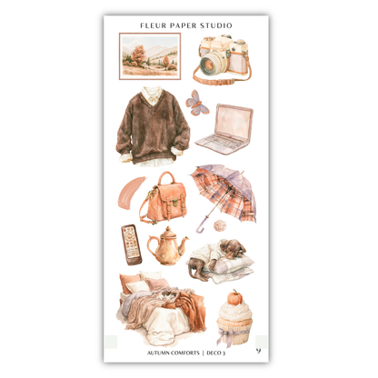various objects and items related to autumn, such as a sweater, camera, laptop, umbrella, cupcake, and bed, all arranged in a collage-like manner.