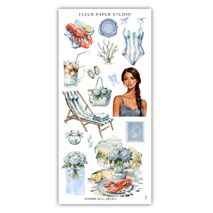 The image is a collage of various objects and illustrations related to the theme of the "Vitamin Sea" and "Deco 2", including a woman, a lobster, a beach chair, a vase of flowers, and other decorative items.